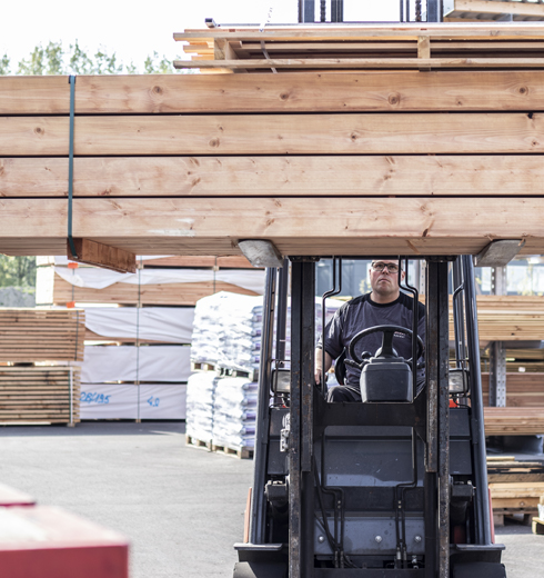 Medewerker verplaatst hout in heftruck